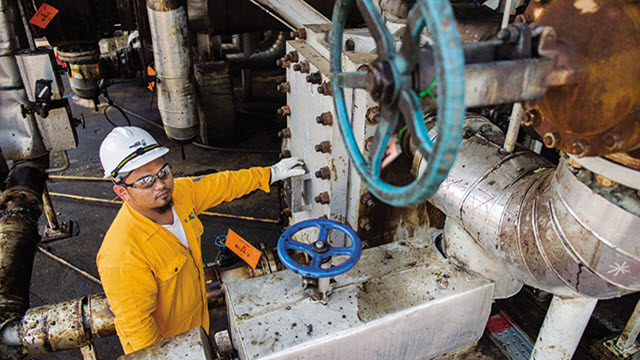 Asian oil refinery worker infront of an installed Alfa Laval Compabloc welded plate heat exchanger