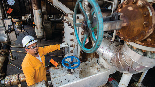 Asian oil refinery worker infront of an Alfa Laval Compabloc welded plate heat exchanger