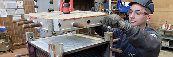 Man working on heat exchanger in welded workshop